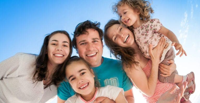 Family looking down at the camera and smiling