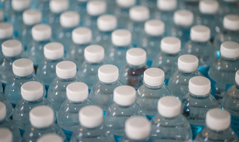Large grouping of water bottles with white plastic caps